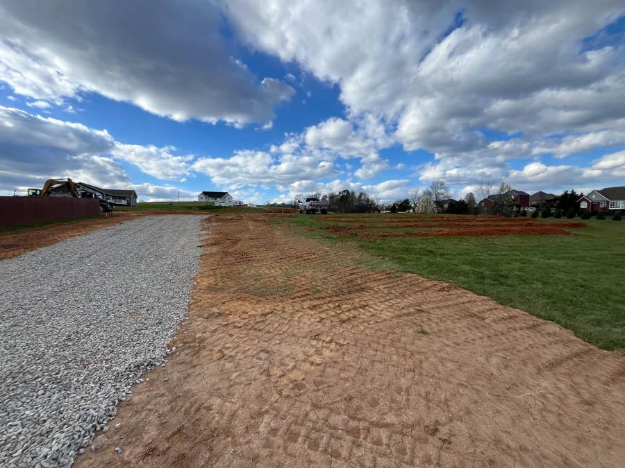 New gravel driveway running alongside a freshly graded yard on a residential lot: driveway and foundation excavation by Rooney Excavating of Seymour, TN