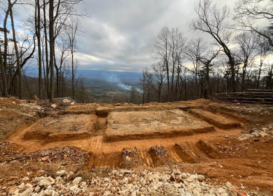 Foundation trenches dug on a mountaintop home site overlooking a wooded valley: driveway and foundation excavation by Rooney Excavating of Seymour, TN