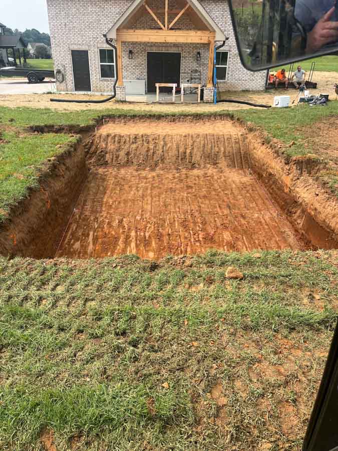 Rectangular excavation dug in a lawn beside a house, seen from the excavator: excavation by Rooney Excavating of Seymour, TN