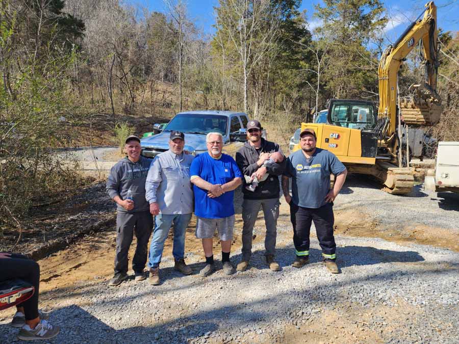The Rooney Excavating team on a job site, in front of an excavator and pickup truck: excavation by Rooney Excavating of Seymour, TN